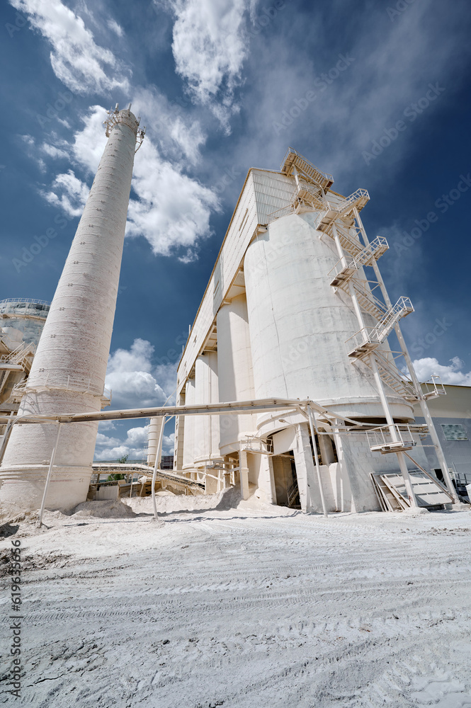 Obraz premium Concrete silos for limestone storage under cloudy sky