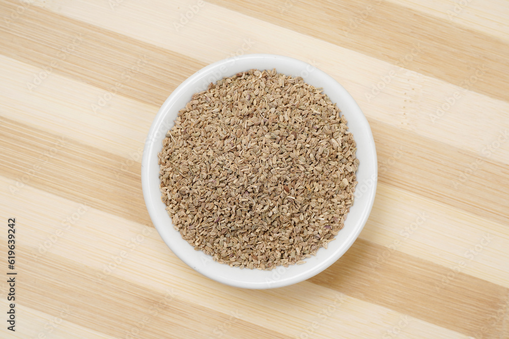 Top view of carom seeds on wooden background, ajwain Top view of carom seeds on wooden background, ajwain