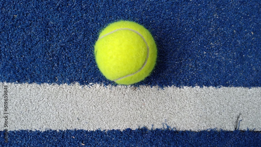 top view of ball to play paddle tennis on blue sport court with white line