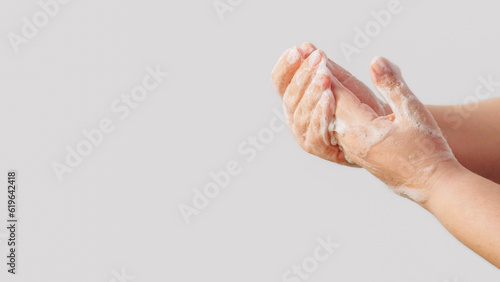 Antibacterial hygiene. Virus prevention. Woman cleansing hands skin with sanitizing soap foam washing off bacteria isolated on white background empty space.