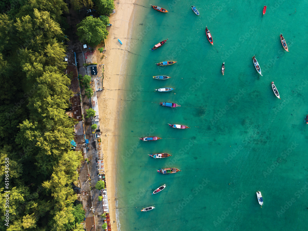 Aerial view drone top down of tourist thai longtail fishing boat in phuket islands,Amazing andaman sea in Phuket Thailand on a sunny morning with beautiful sea surface background