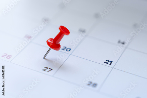 Embroidered red pins on a calendar event or travel planning concept.