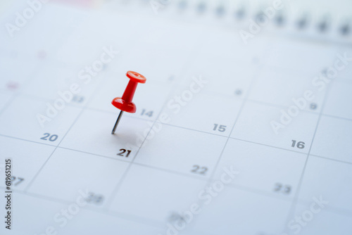 Close-up view of red pins with calendar for meeting reminders and appointments.