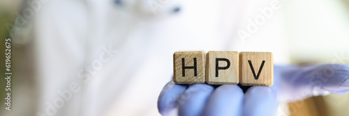 Female practitioner hand holding wooden cubes with word hpv photo