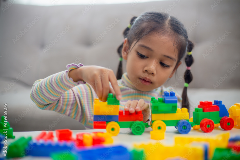 custom made wallpaper toronto digitalAdorable little girl playing toy blocks in a bright room.