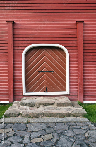 closed doorway on red painted wooden wall outdoors