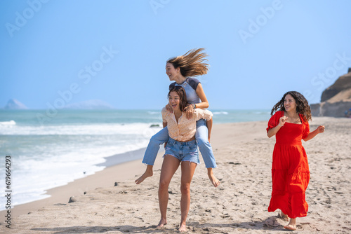 Friends having fun running and jumping on the seashore