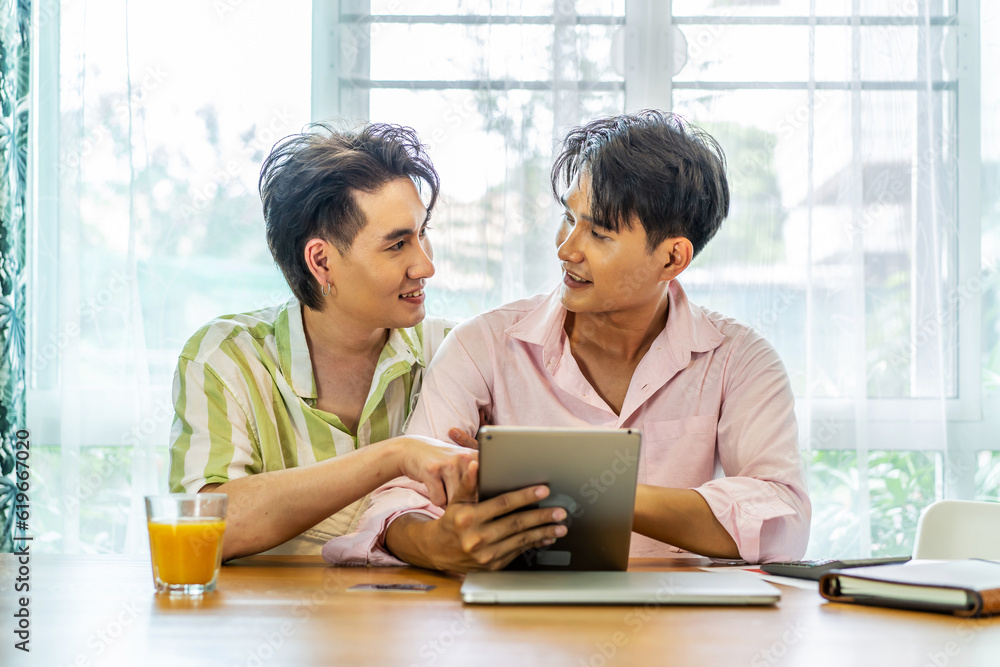 Attractive male lgbtq collegues working together with using digital tablet and paper showing graphic chart in living room, Lgbt love concept Attractive male lgbtq collegues working together with using digital tablet and paper showing graphic chart in living room, Lgbt love concept