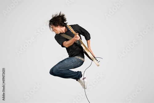 Stylish musician playing guitar on background.