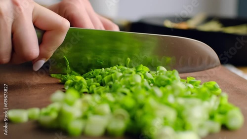 Chopping spring onion. Chef cutting raw green onion with knife, chopped organic vegetable ingredient for cooking, healthy salad spice flavoring