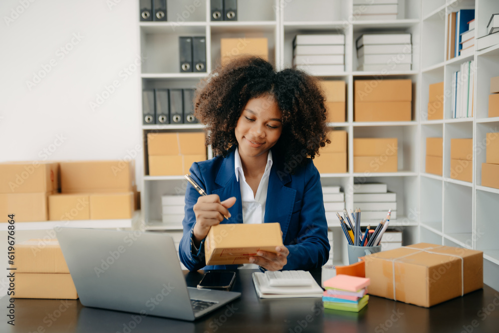 Startup small business SME, Entrepreneur owner African woman using smartphone or tablet taking receive and checking online purchase shopping order Startup small business SME, Entrepreneur owner African woman using smartphone or tablet taking receive and checking online purchase shopping order
