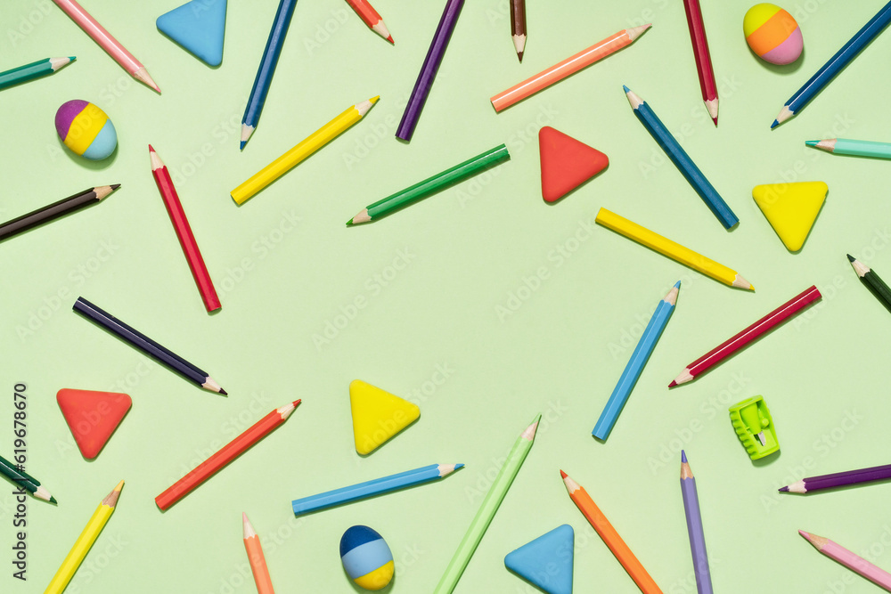 Colored Pencils and rubber erasers background pattern on light green. Back to School or drawing and creativity concept. Copy space in center. Top view Colored Pencils and rubber erasers background pattern on light green. Back to School or drawing and creativity concept. Copy space in center. Top view