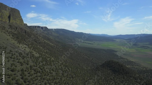 Geological Formation Of Abert Rim Covered With Green Foliage In Lake County, Oregon. aerial pan right photo