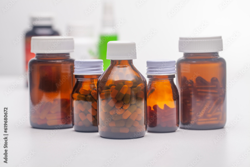Multiple unlabeled pill bottles placed on a white background Multiple unlabeled pill bottles placed on a white background