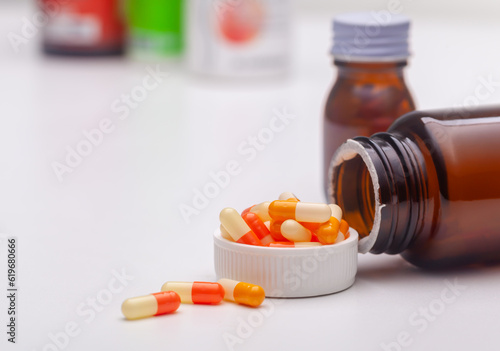 Top view, pill bottle and pills laying on white background