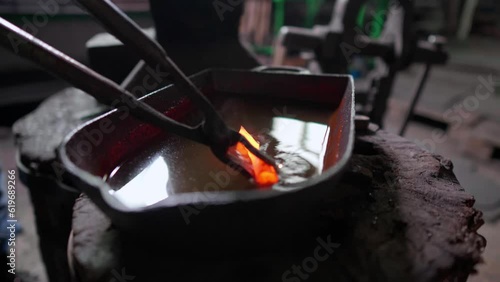 Blacksmith quenching hot metal arrowhead
