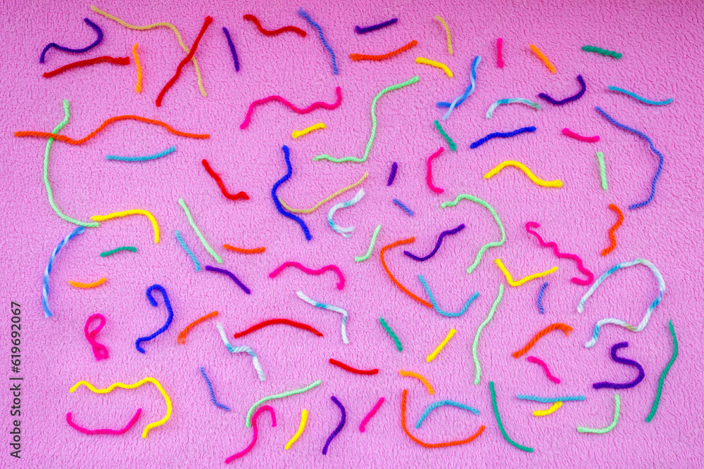 Colorful threads on pink background Colorful threads on pink background
