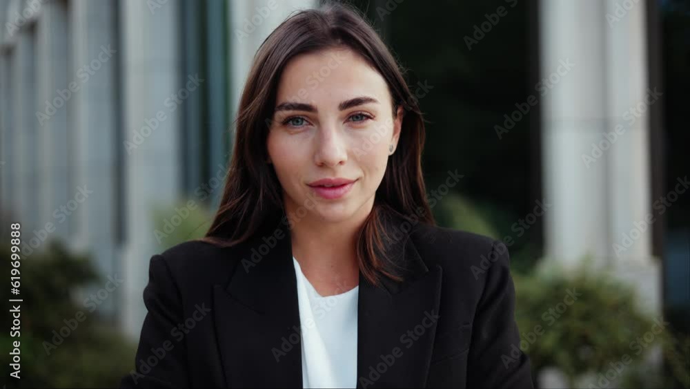 A young, confident businesswoman, dressed in a formal suit, poses outdoors near a company building. Closeup face portrait, looking directly at camera with a radiant smile, exuding beauty and style. A young, confident businesswoman, dressed in a formal suit, poses outdoors near a company building. Closeup face portrait, looking directly at camera with a radiant smile, exuding beauty and style.