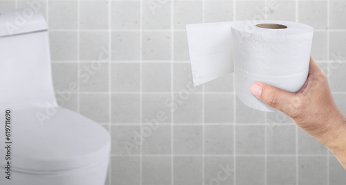 A person suffering from diarrhea holds a roll of toilet paper in front of the toilet bowl