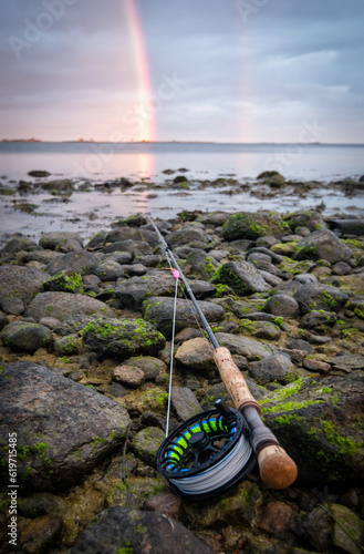 Fly rod on the sea coast with rainbow