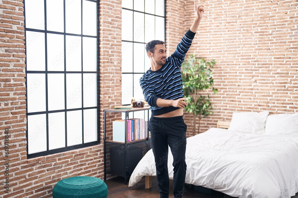 Young hispanic man smiling confident dancing at bedroom