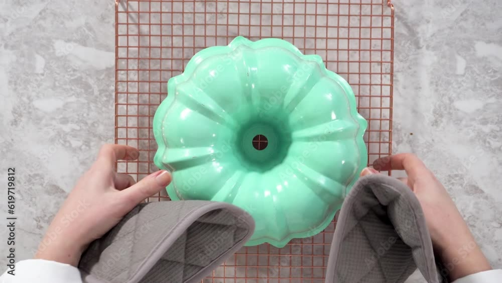 Flat lay. Removing freshly baked funfettti bundt cake from the bundt