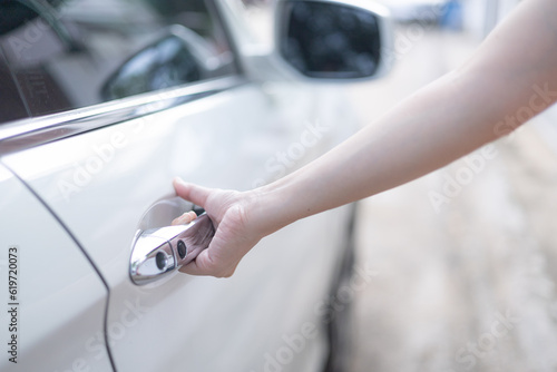 Close-up of a woman hand opening a white car door. Automotive concept. opening doors, concept cars, driving safely