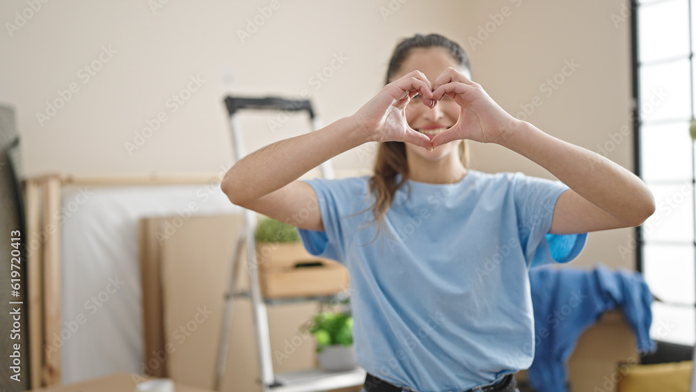 Young beautiful hispanic woman doing heart gesture at new home Young beautiful hispanic woman doing heart gesture at new home