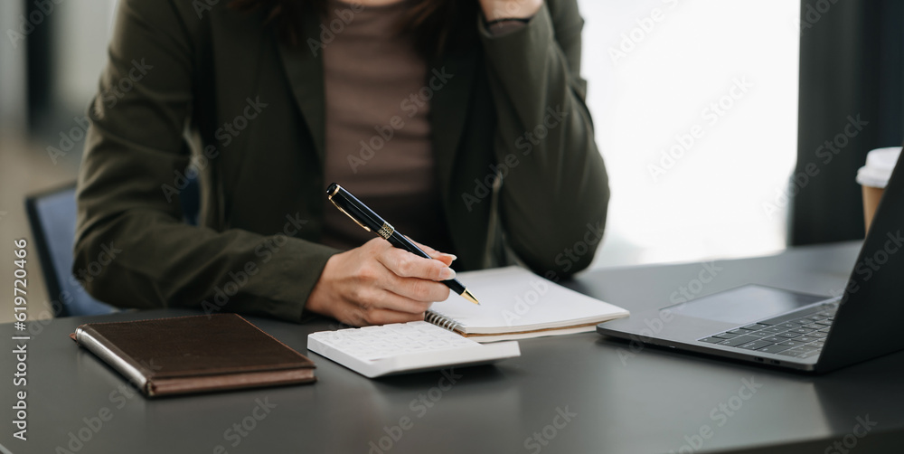 businesswoman hand working with new modern computer and writing on the notepad strategy diagram as concept morning light. businesswoman hand working with new modern computer and writing on the notepad strategy diagram as concept morning light.