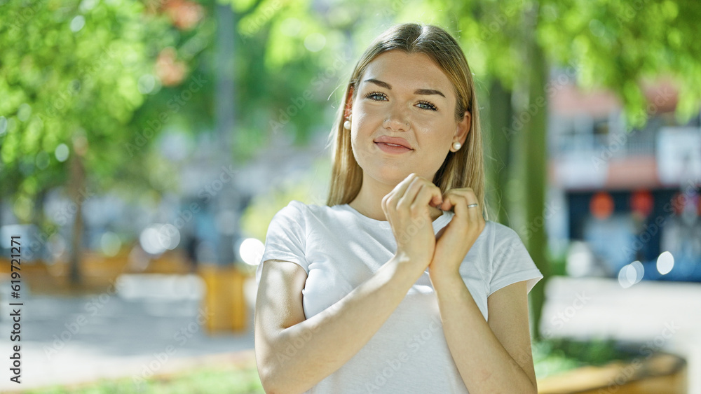 Young blonde woman smiling confident doing heart gesture with hands at park Young blonde woman smiling confident doing heart gesture with hands at park