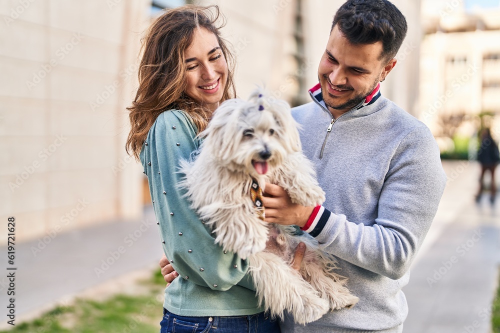 Man and woman holding dog hugging each other at street Man and woman holding dog hugging each other at street