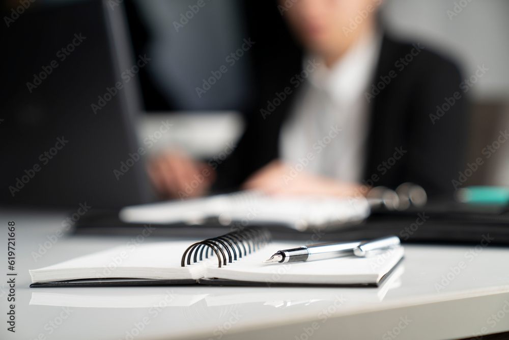 Female secretary working in the office. Notepad on the white table. - obrazy, fototapety, plakaty 