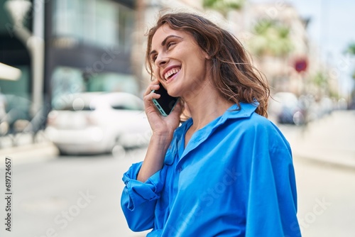Young woman smiling confident talking on the smartphone at street © Krakenimages.com