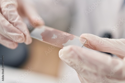 Young blonde woman scientist holding blood sample at laboratory