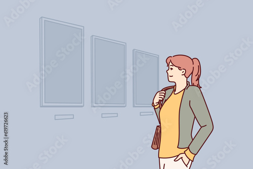 Woman visiting art gallery looks at paintings hanging on wall, painted by classical or contemporary artists. Young girl is in art exhibition hall contemplating work of famous painters.
