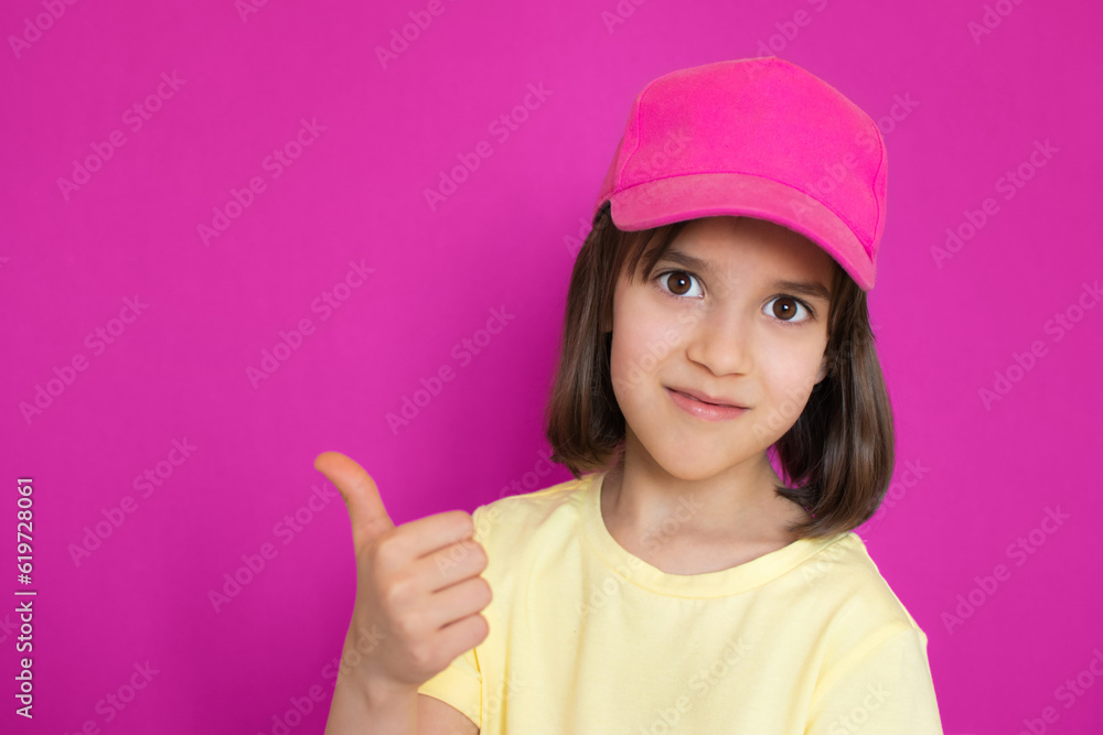Portrait of smiling cute little toddler girl showing thumb up with hands over pink magenta Portrait of smiling cute little toddler girl showing thumb up with hands over pink magenta