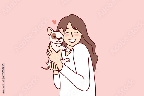 Little girl hugs puppy given for birthday and rejoices at dog become best friend for child. Happy female teenager with miniature dog enjoys interacting with cute pet adopted from shelter