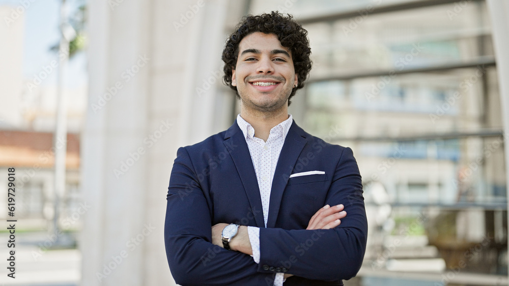 Young latin man business worker smiling confident standing with arms crossed gesture at street Young latin man business worker smiling confident standing with arms crossed gesture at street