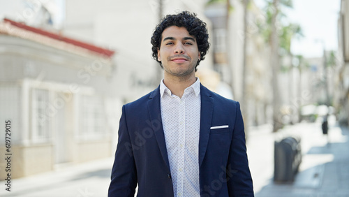 Young latin man business worker smiling confident standing at street