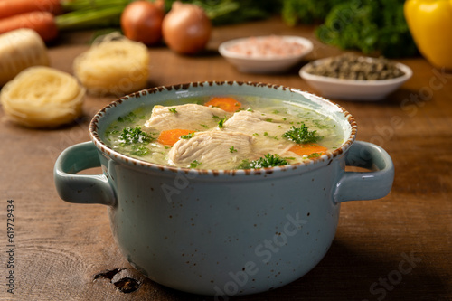 Delicious fresh homemade chicken soup with noodles. Supa de pui cu taitei. Traditional polish/romanian food. Wooden background. photo