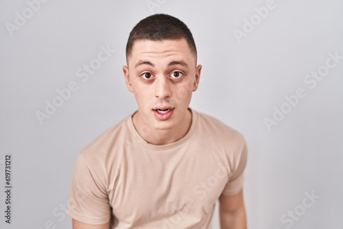 Young man standing over isolated background afraid and shocked with surprise and amazed expression, fear and excited face.