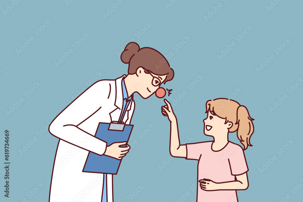 Woman doctor with red nose leans towards little girl for concept of treating children in pediatric clinic. Doctor wants to cheer up child and provide psychological support conducive to recovery