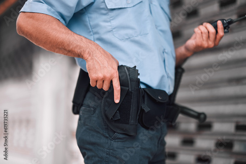 Closeup, law or police officer with a gun, safety or career with legal enforcement, armed or crime. Zoom, man or security guard with service weapon, protection or danger with walkie talkie or uniform