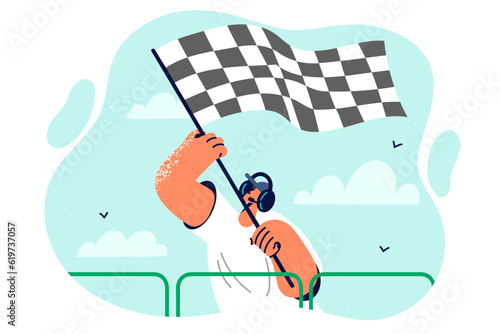 Starting flag in hands of man announcing start of race and giving signal to drivers high-speed cars