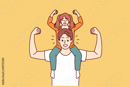 Little daughter sits on shoulders of strong father and demonstrates biceps, wanting to become like dad. Preteen girl together with father or older brother for generational succession concept