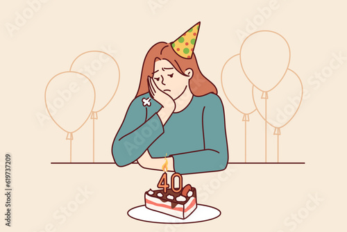 Lonely woman at birthday party with cake and balloons is sad due to approach of old age or lack of friends. Distressed girl in birthday hat sits at festive table and needs psychological support