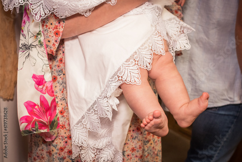 Feet of a child at the sacrament of baptism. A little girl's foot and a white canvas.