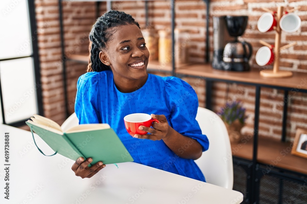 African american woman reading book and drinking coffee at home African american woman reading book and drinking coffee at home