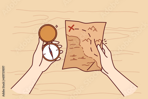 Treasure map and compass in hands of man looking for expensive jewels lost at sea from pirate vessels. Gold digger and adventurer in search of treasure or sunken ship explores ocean coast