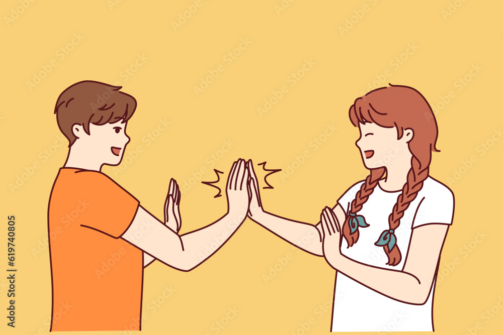 Children play hand-clapping laughing and enjoying teenage friendship and happy childhood. Boy and girl play hand-clapping after school for concept of children socialization through active games Children play hand-clapping laughing and enjoying teenage friendship and happy childhood. Boy and girl play hand-clapping after school for concept of children socialization through active games